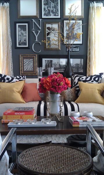 An arrangement of framed artworks creating a gallery wall behind a couch.