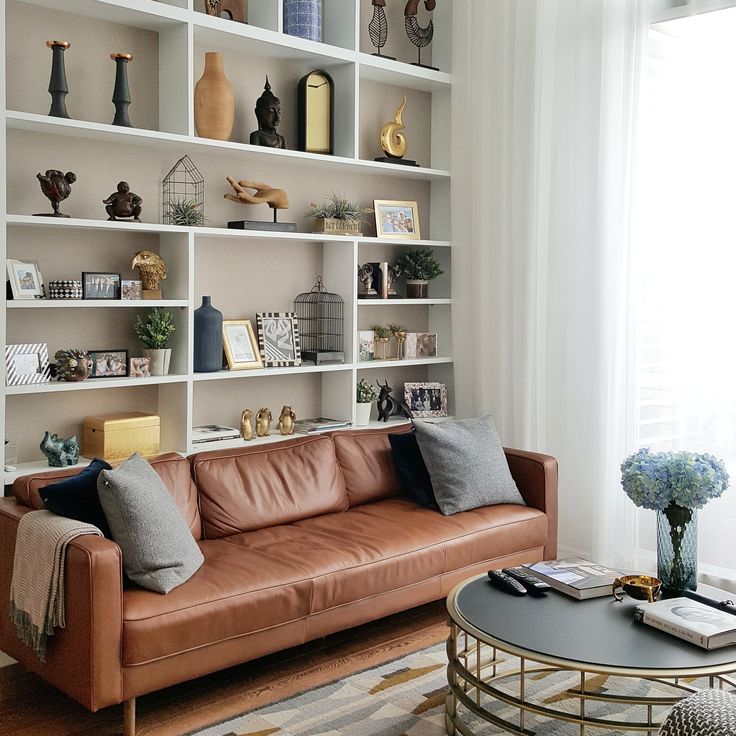 Floor-to-ceiling bookshelves filled with books behind a sofa.