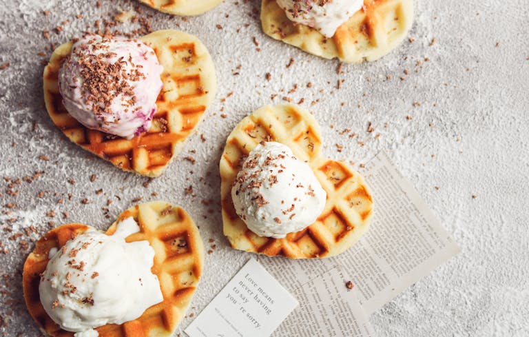 Delicious heart-shaped waffles topped with creamy vanilla and strawberry ice cream.