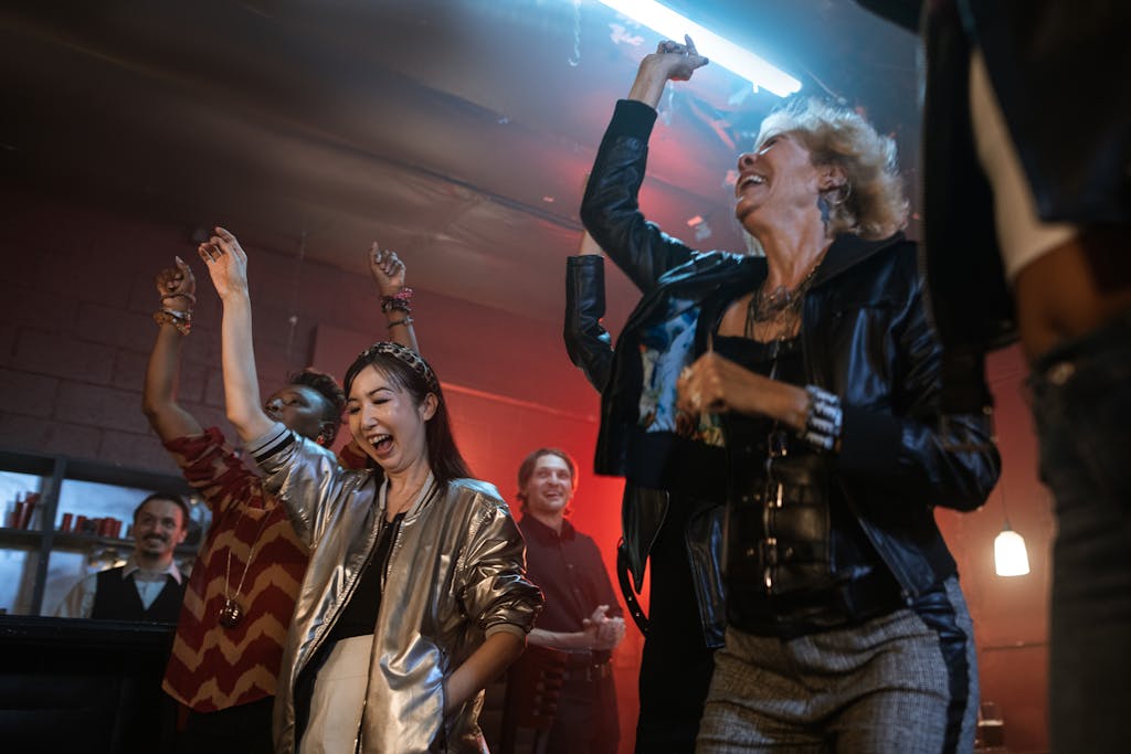 Energetic group of people enjoying a fun night out dancing and smiling at a lively club.