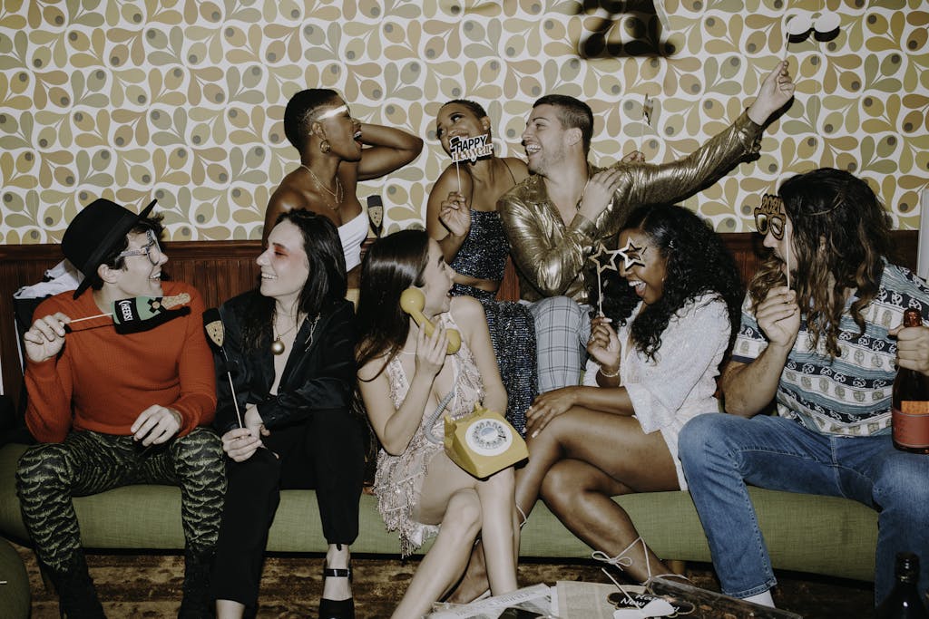 Group of friends enjoying a lively New Year's Eve party with laughter and festive decorations.