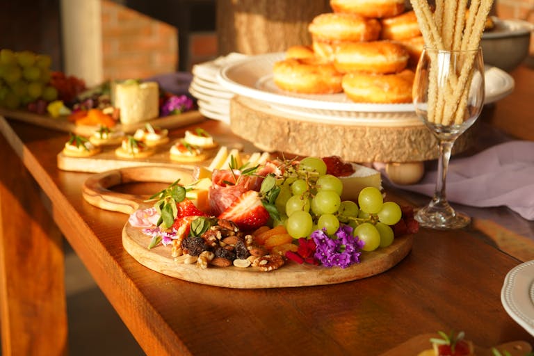 A vibrant breakfast buffet featuring fresh fruits, pastries, and nuts arranged on wooden boards.