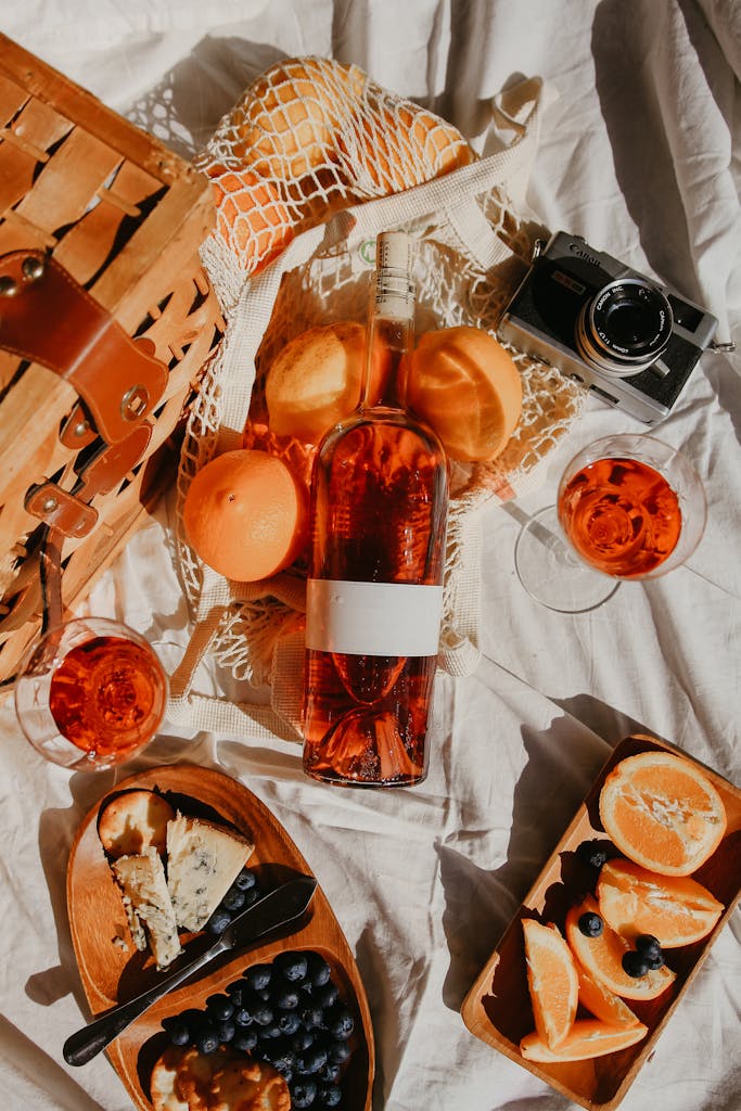 A top view of a stylish picnic setup in Napa with wine, fruits, and cheese.