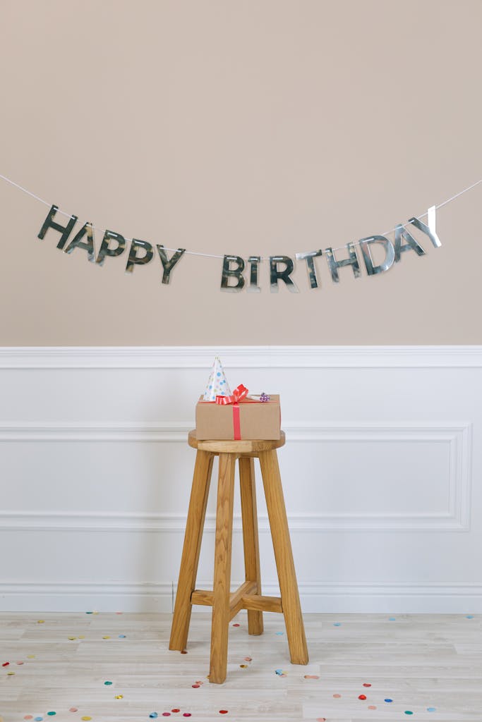 A festive indoor birthday scene with gifts on a stool and decorations.