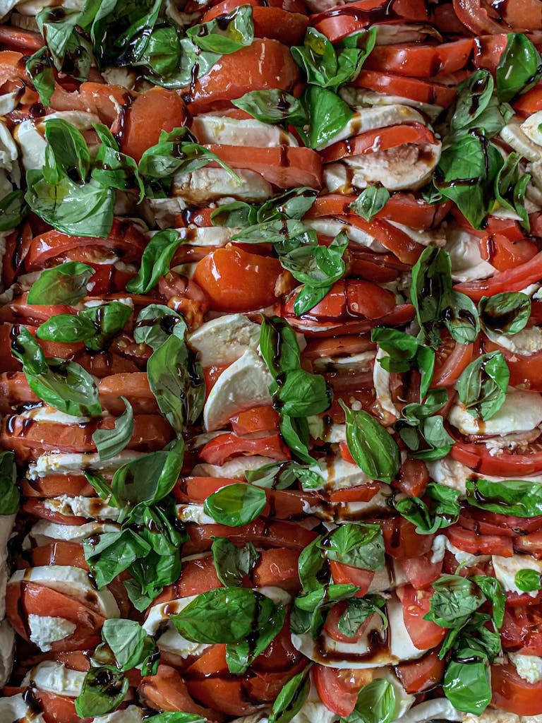 Mouthwatering Caprese salad with ripe tomatoes, basil, mozzarella, and balsamic glaze.