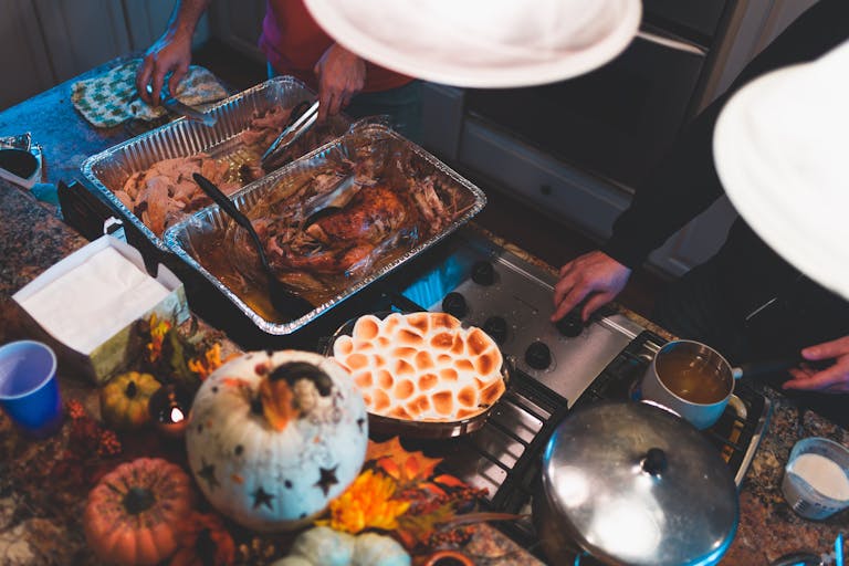 Top view of a Thanksgiving meal preparation with turkey and sweet potatoes indoors.