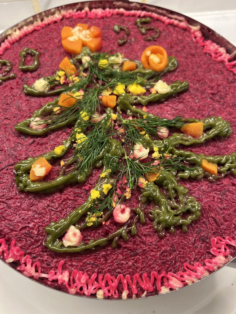 Vibrantly decorated beet salad with holiday tree motif, perfect for festive celebrations.