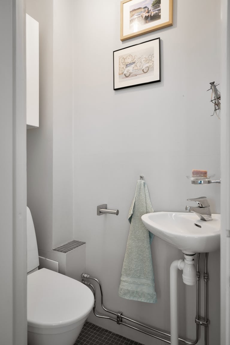 Stylish minimalist bathroom with sink and toilet showcasing modern interior design.