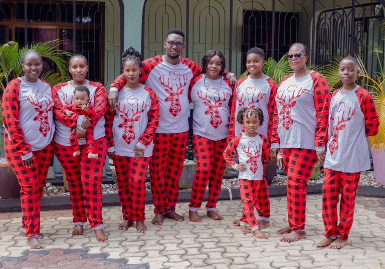 Happy family celebrating in matching plaid pajamas, outdoors setting.